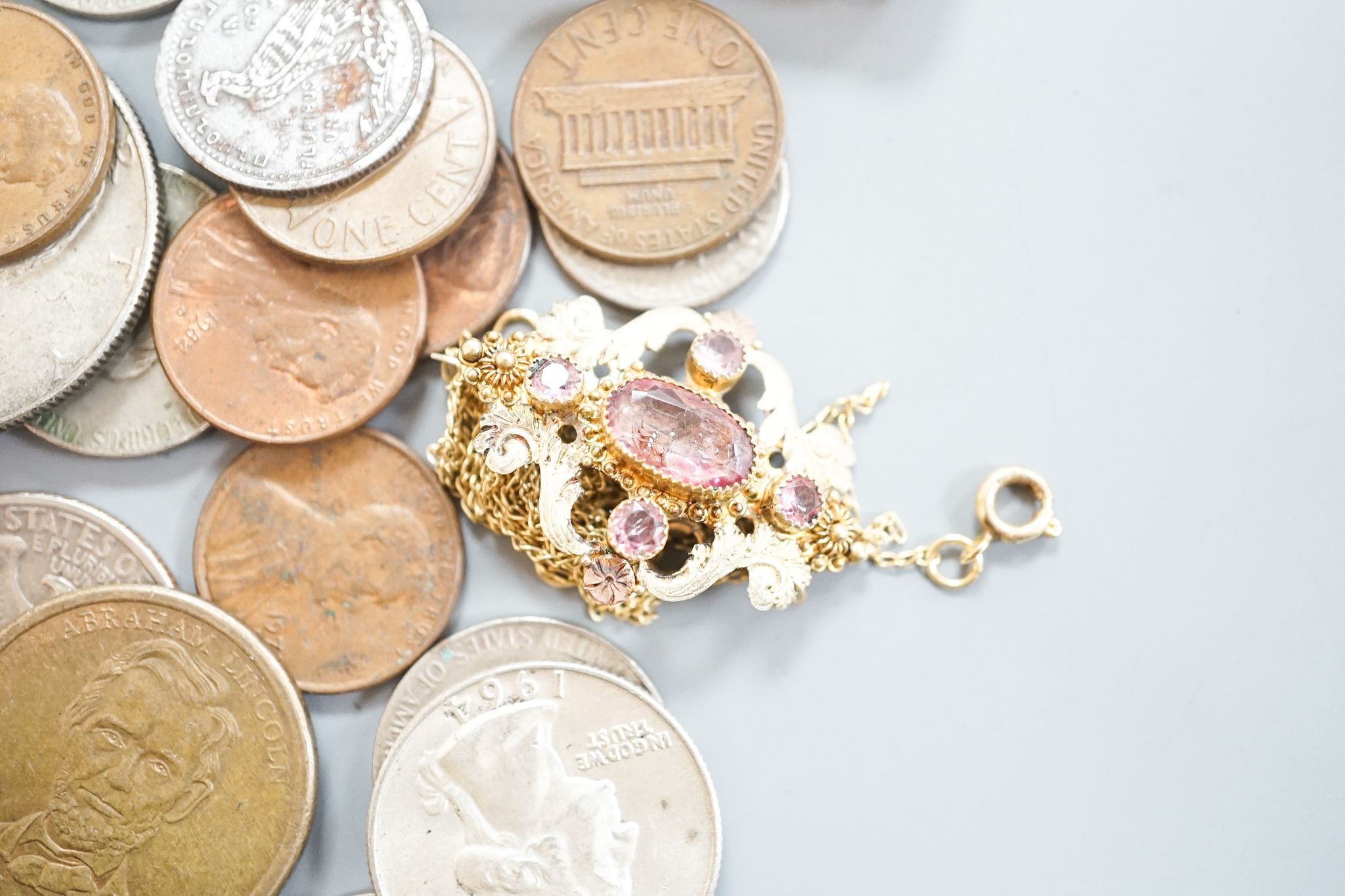 A 19th century two colour yellow metal and pink topaz set brooch, 30mm, an amber cigarette holder, gilt metal chain and a group of assorted coinage and bank notes.